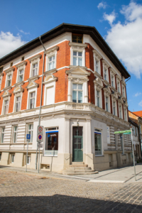 Freizeit- und Begegnungsstätte (FuBs) Breite Straße 21 in Eberswalde - Lebenshilfe Barnim Die Freizeit- und Begegnungsstätte befindet sich in einem dreistöckigem Gebäude an der Ecke Salomon-Goldschmidt Straße / Breite Straße. Das Erdgeschoss ist hell verputzt. Die beiden oberen Etage haben eine Ziegel-Fassade. In der Ecke ist eine grüne Eingangstür, rechts und links davon sind zwei große Schaufenstern.