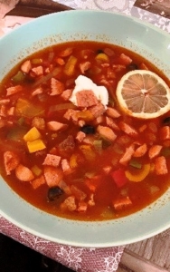 Eine leckere Soljanka mit einer Scheibe Zitrone und einem Klecks Sahne.