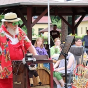 Clown Henry ist bekleidet mit roter Latzhose, roter, bedruckt er Jacke und weißem Strohhut. Er bedient seine Drehorgel (Leierkasten). Vorn an der Drehorgel steht die Aufschrift: Orgel Henry. Auf der Orgel steht eine kleine Kasse, an der ein kleiner Plüsch-Affe hängt. Hinter Orgel-Henry sitzt junges Publikum.