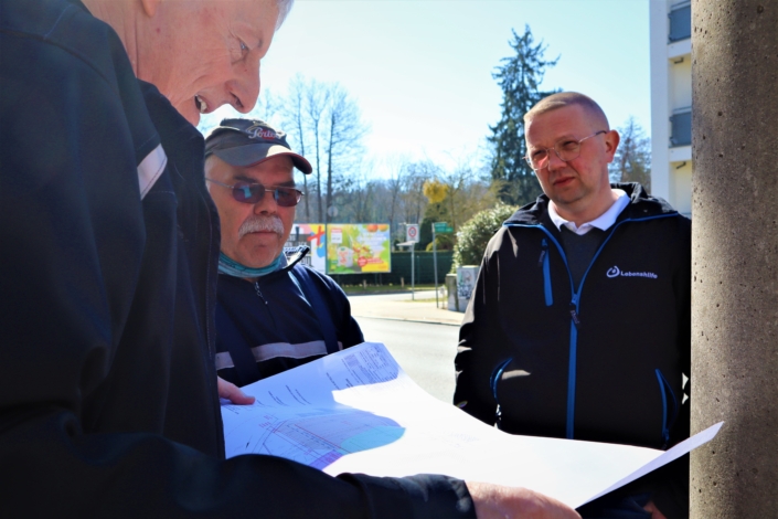 Baubeginn Raumerstraße – Baubesprechung Herr Lutter, Geschäftsführer der gGmbH Lebenshilfe Wohnstätten Barnim, bespricht mit zwei Mitarbeitern der Baufirma die weiteren Arbeiten. Dabei schauen sie auf eine Zeichnung.