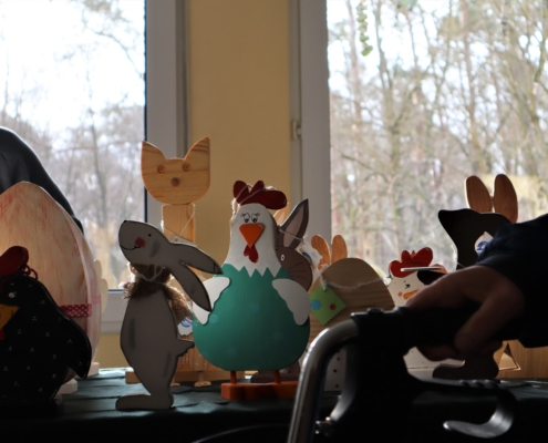 Großaufnahme verschiedener bunter Holzfiguren wie Hühner, Osterhasen und eine Katze.
