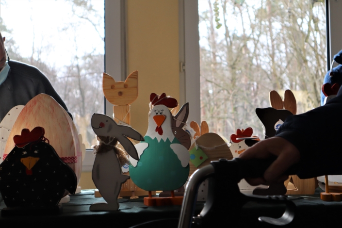 Sonnenhof Osterbasar – schöne Osterdekoration Großaufnahme verschiedener bunter Holzfiguren wie Hühner, Osterhasen und eine Katze.