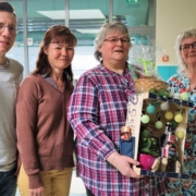 Auf Foto von links: Geschäftsführer Thomas Herzberg, pädagogische Leiterin Frau Wiese, Gruppenleiterin Conny, Produktionsleiterin Manuela Bester. Conny hält eine Geschenkekiste mit Lichterkette in den Händen.