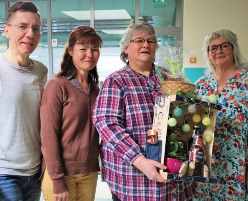 Auf Foto von links: Geschäftsführer Thomas Herzberg, pädagogische Leiterin Frau Wiese, Gruppenleiterin Conny, Produktionsleiterin Manuela Bester. Conny hält eine Geschenkekiste mit Lichterkette in den Händen.