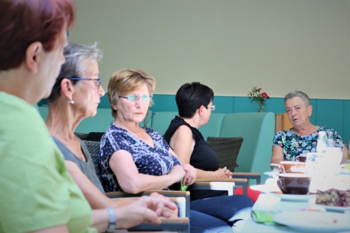 Im Gespräch Fünf Frauen unterhalten sich in einer zweier und einer dreier Gruppe.